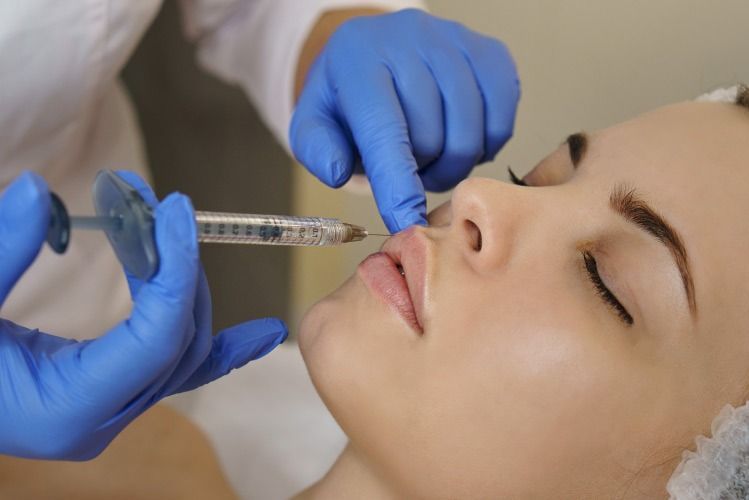Una mujer recibe una inyección en el labio.