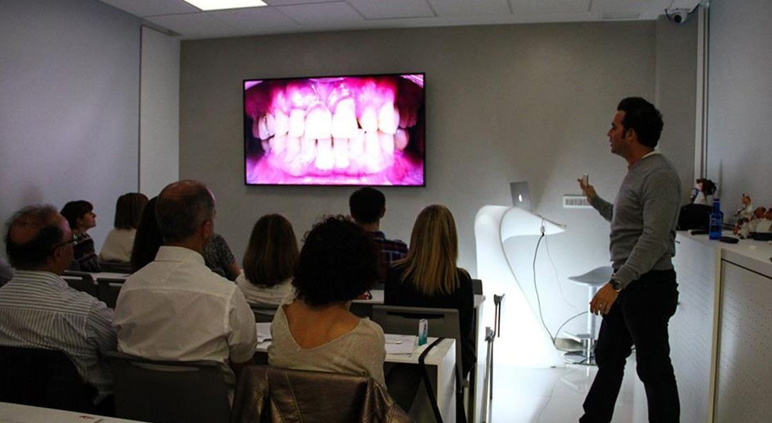 Un hombre está dando una presentación a un grupo de personas en un aula.