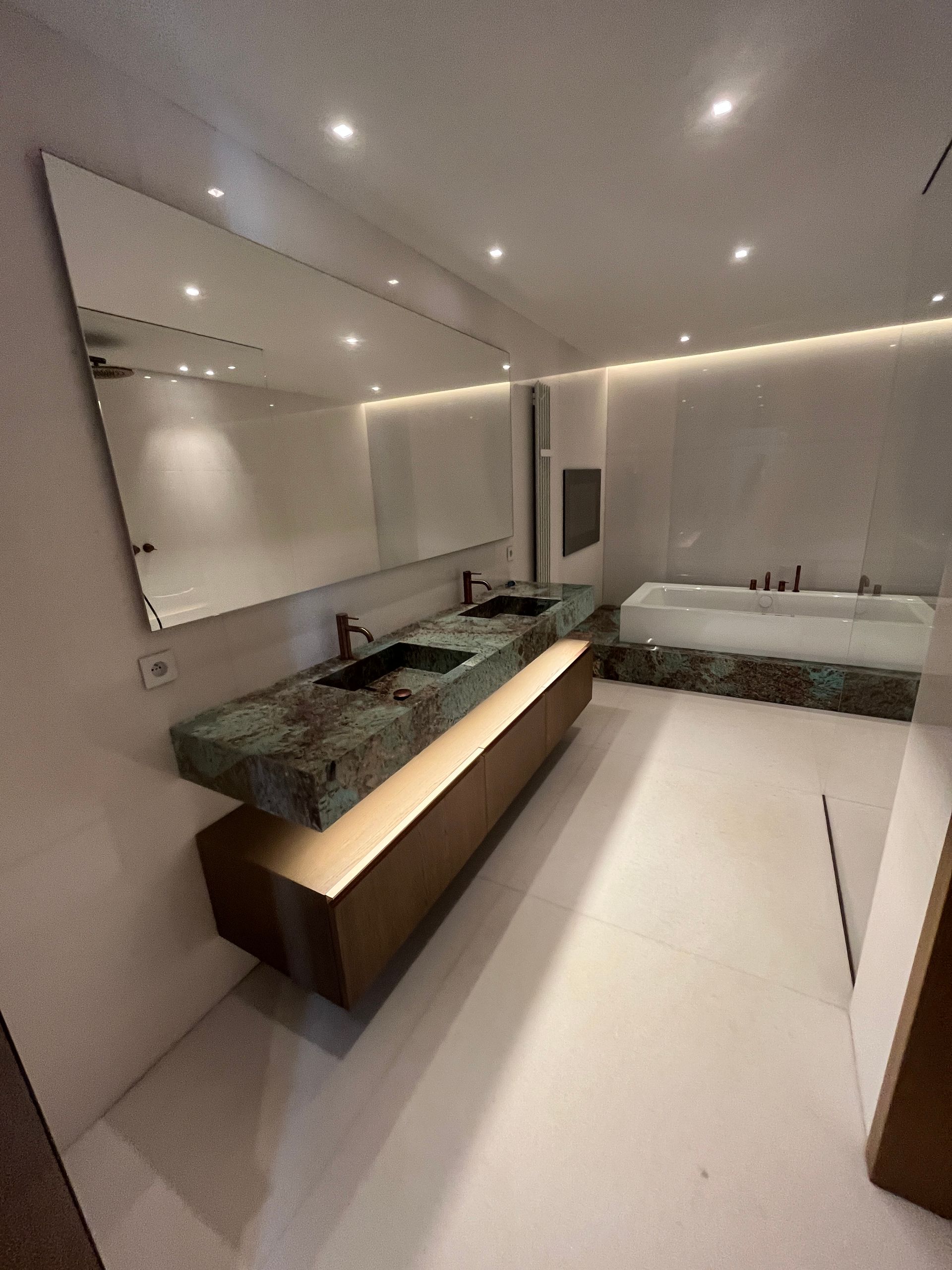 Salle de bains avec lavabo, grand miroir et baignoire 