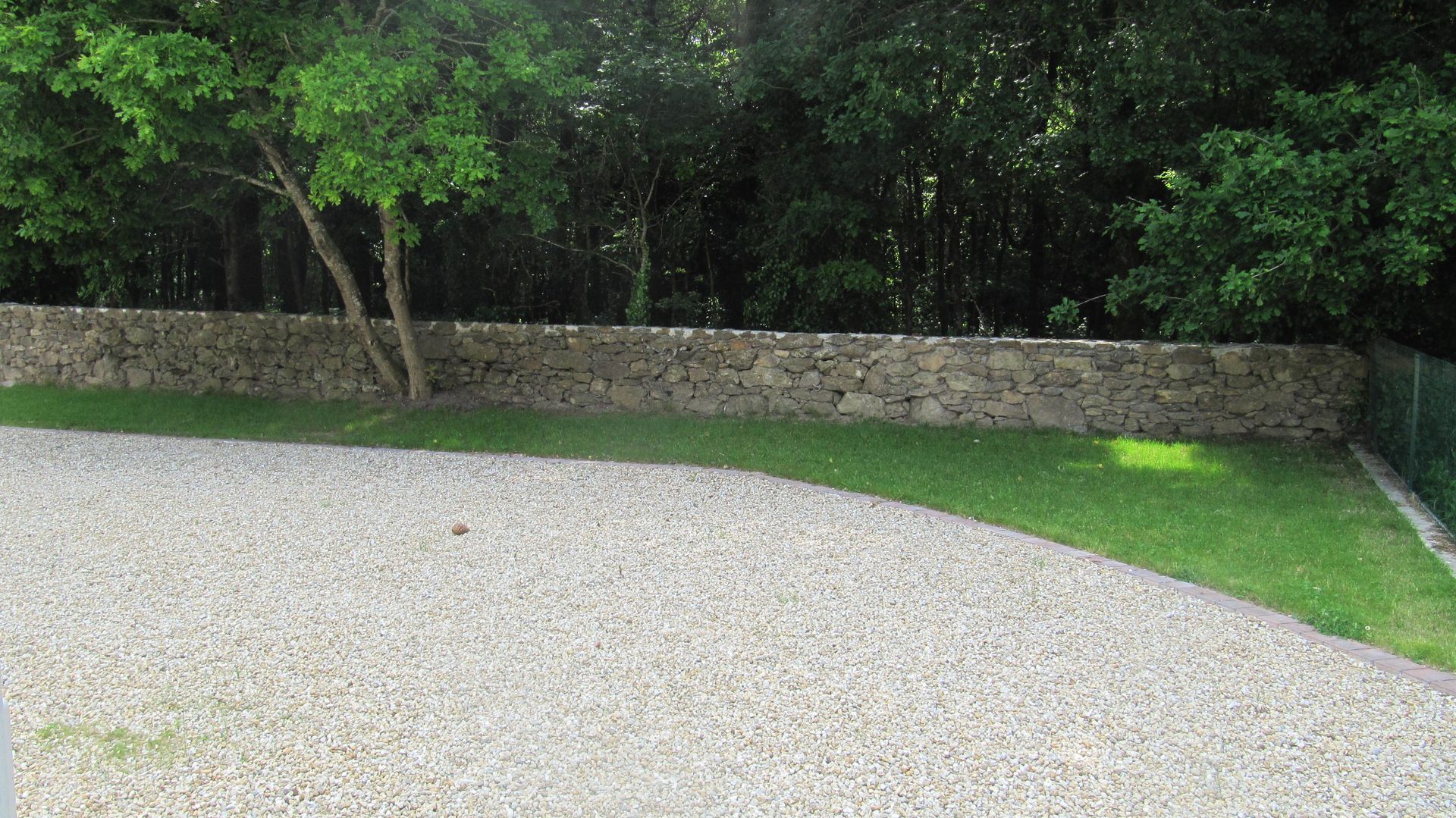 Cour en graviers et mur en pierres