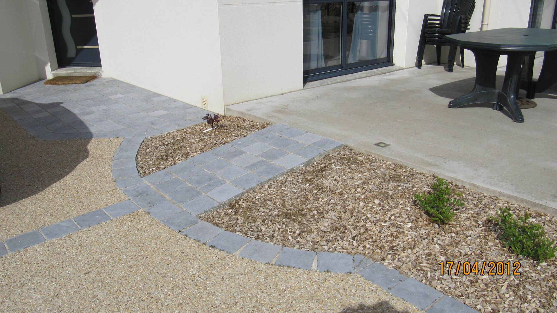 Chemin en béton drainant et pavés qui mène à une terrasse