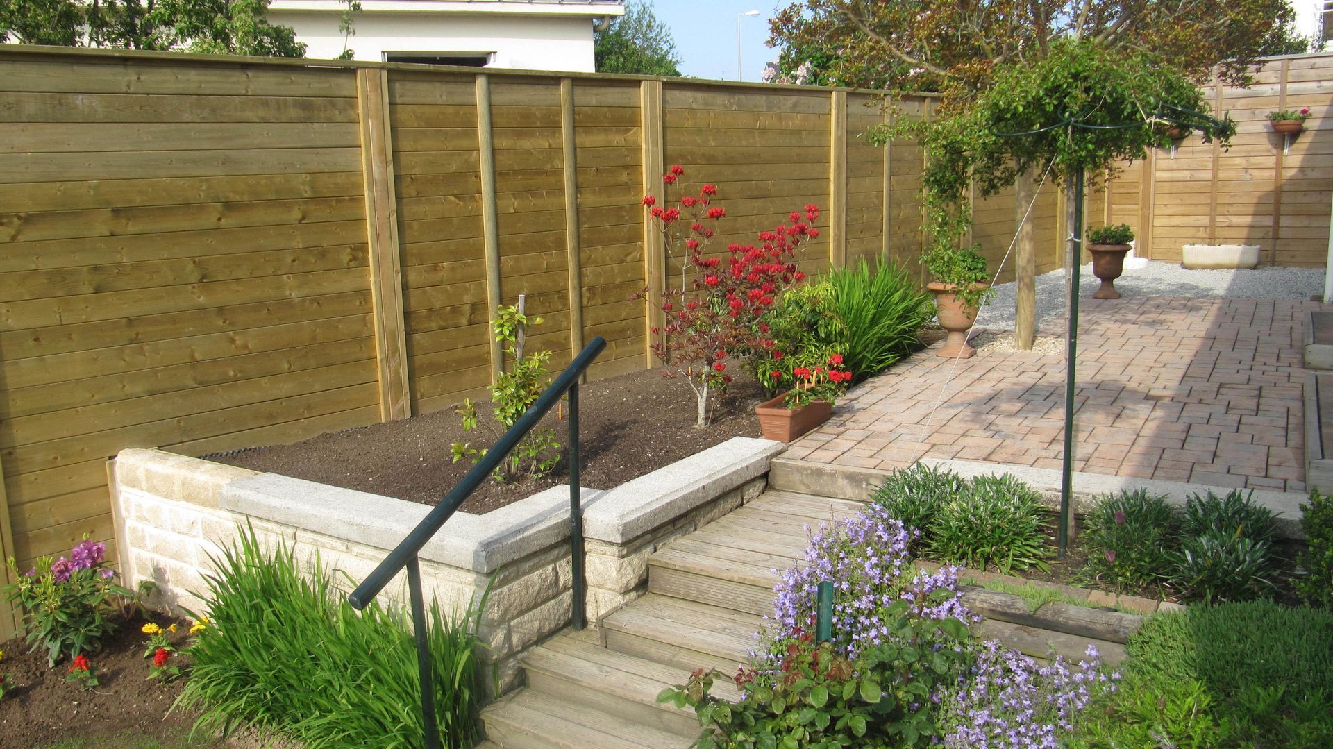 Palissade en bois le long d'une terrasse en pavés