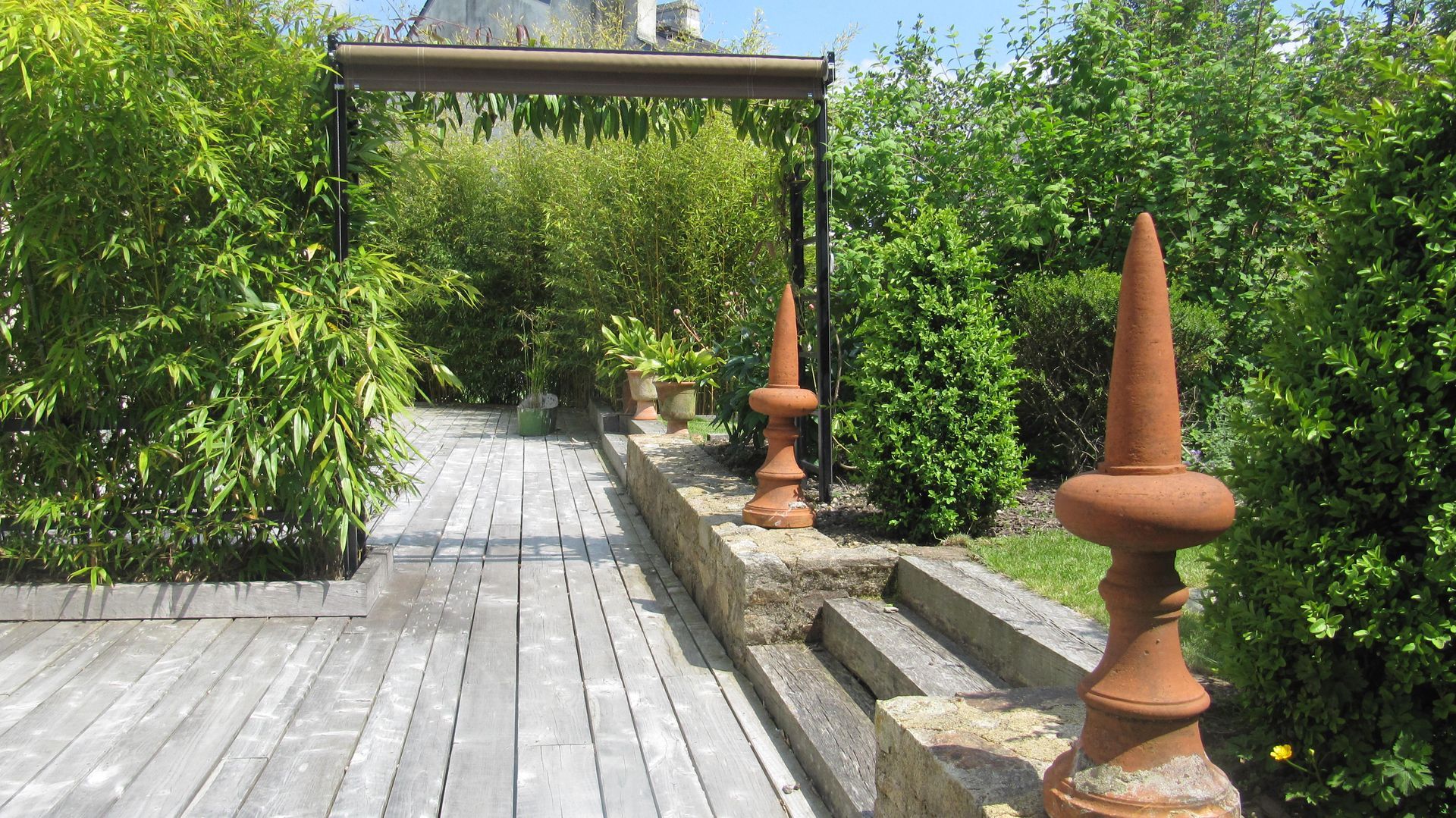 Terrasse en bois, pergola et décorations en terre cuite