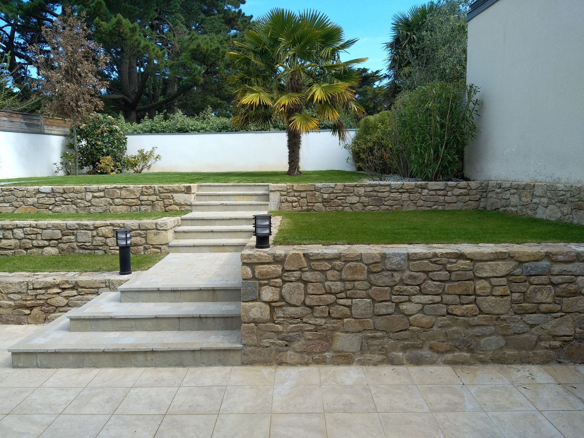 Un jardin en paliers, des murets en pierre et du gazon