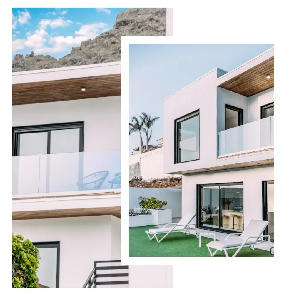 Moderna casa blanca con balcones de cristal, tumbonas en césped verde y vistas a la montaña.