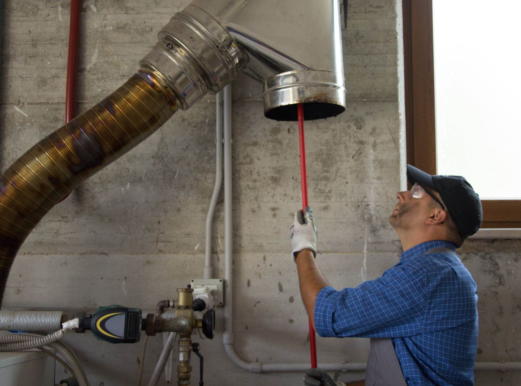 Un technicien effectue l'entretien des conduits de chaudière