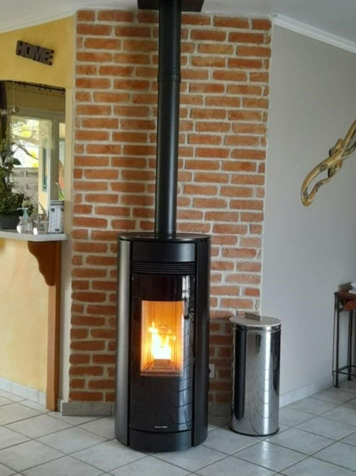 Un poêle à granulés est allumé dans le coin de la pièce