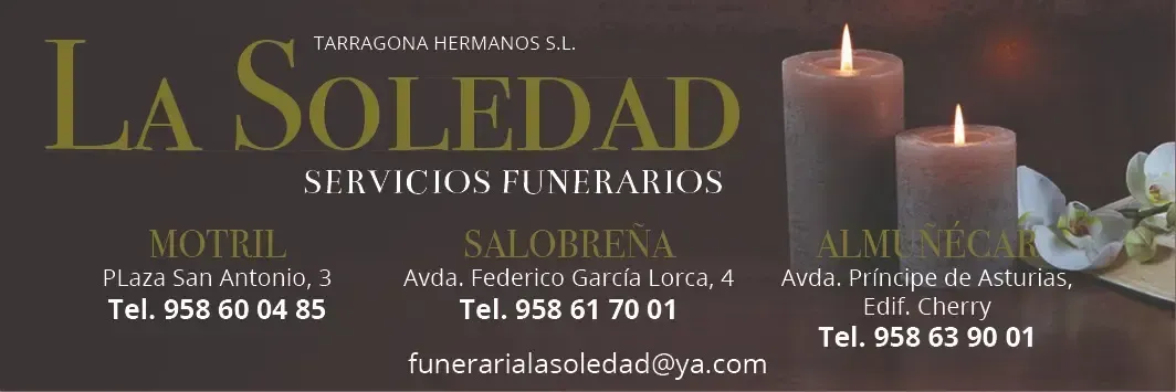 Pancarta conmemorativa para La Soledad, con velas, flores y números de teléfono de contacto.
