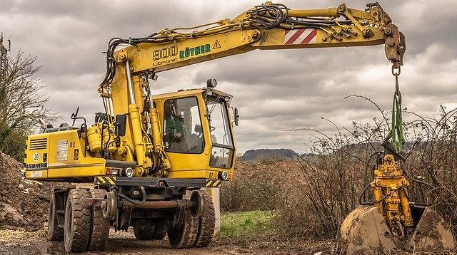 Una excavadora amarilla está cavando un hoyo en la tierra.