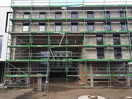 Gebäudefassade mit grünem Gerüst im Bau