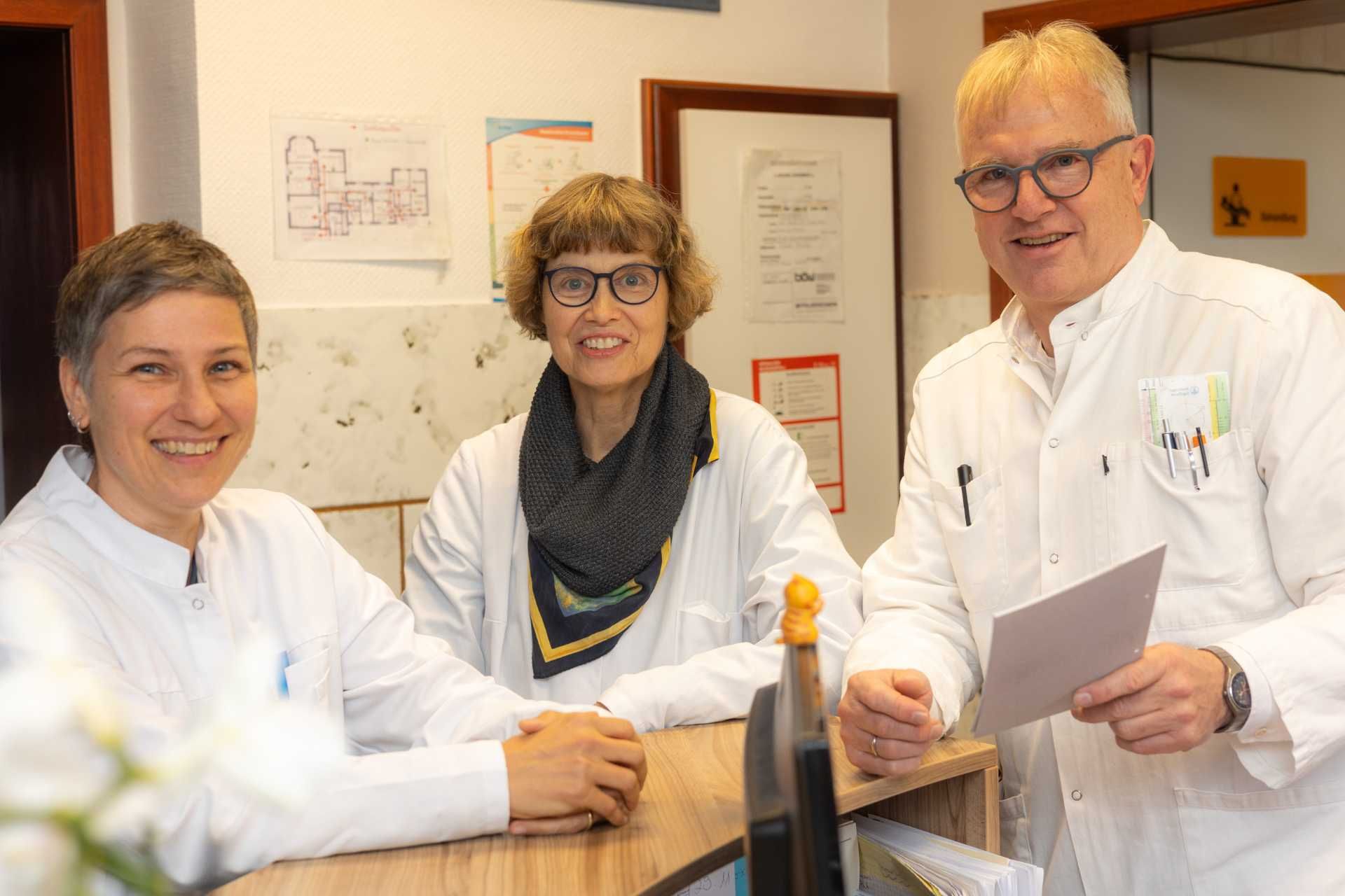 Unsere drei Ärzte – Dr. med. Wiebke Billecke, Dr. med. Klaus & Andrea Egen – am Empfangstresen Unsere drei Ärzte – Dr. med. Wiebke Billecke, Dr. med. Klaus & Andrea Egen – am Empfangstresen