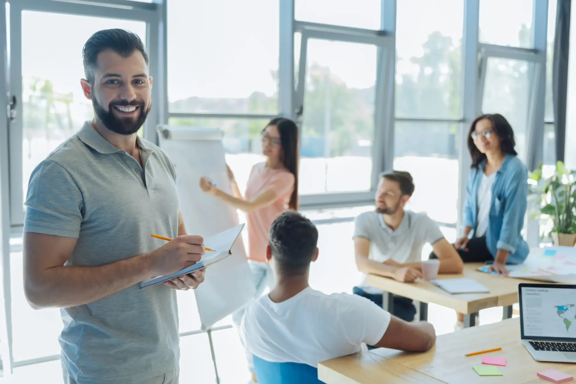 Un hombre está dando una presentación a un grupo de personas en una oficina.