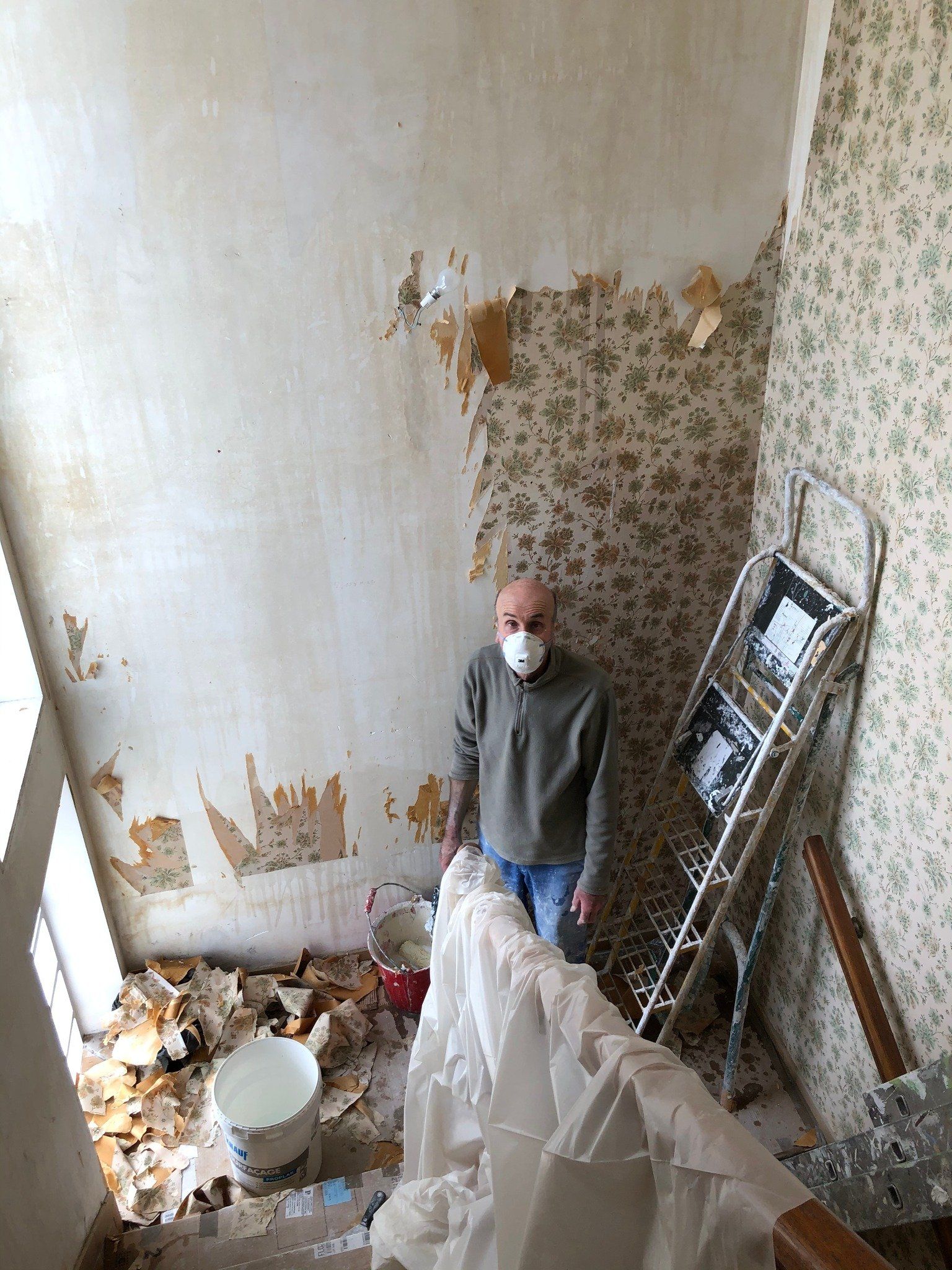 Ouvrier en train de décoller de la tapisserie