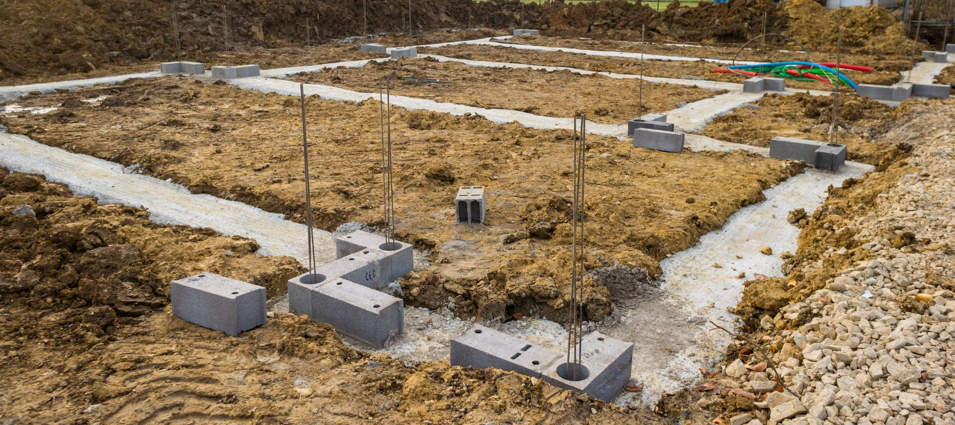 Chantier de construction de fondations avec semelles en béton apparentes et terre