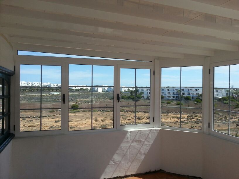 Una habitación con muchas ventanas y vista al desierto.
