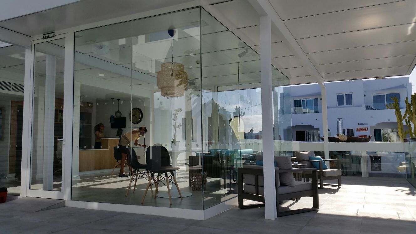 Una habitación con muchas ventanas y sillas.