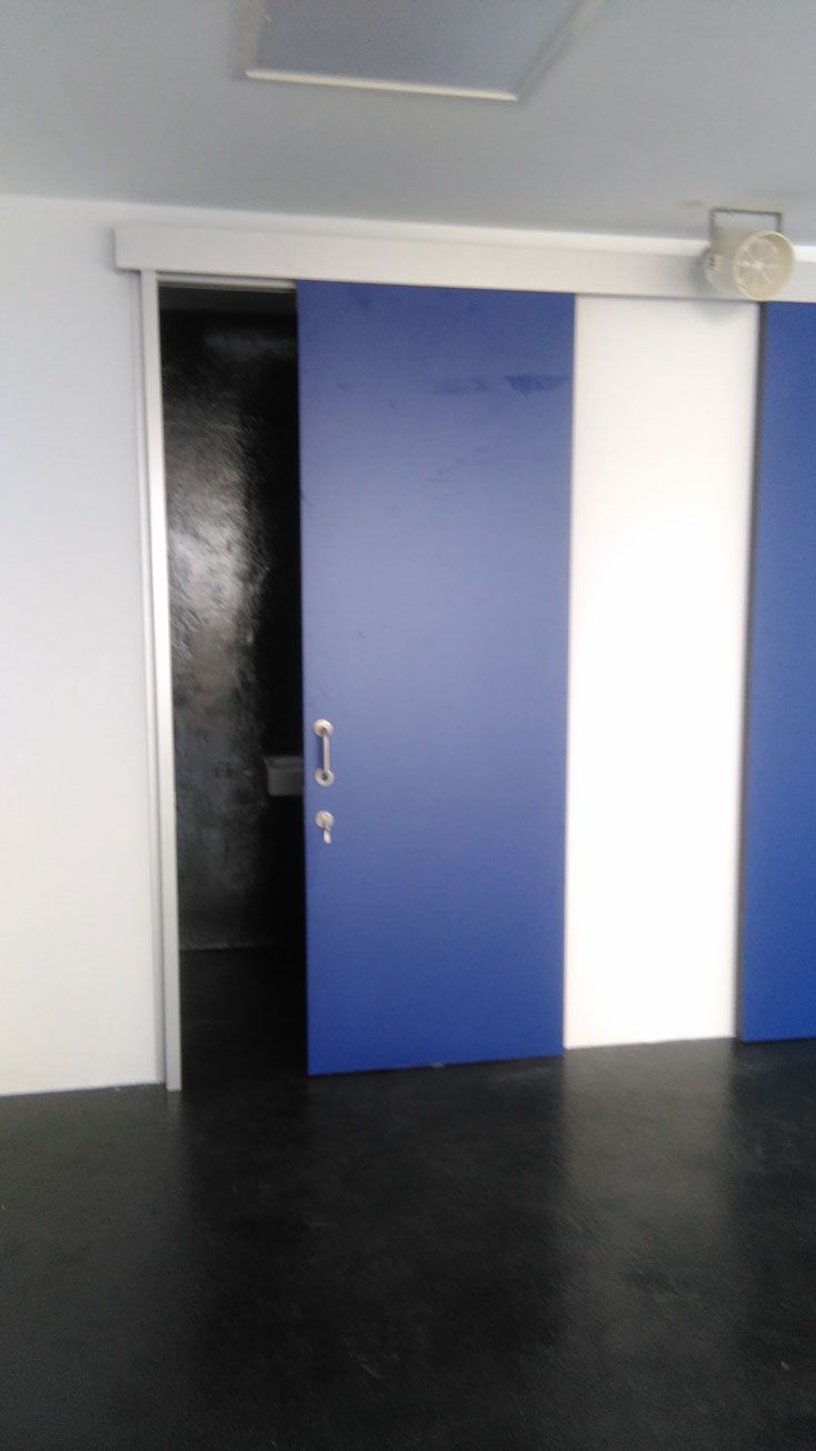 Una habitación con puertas corredizas azules y blancas.