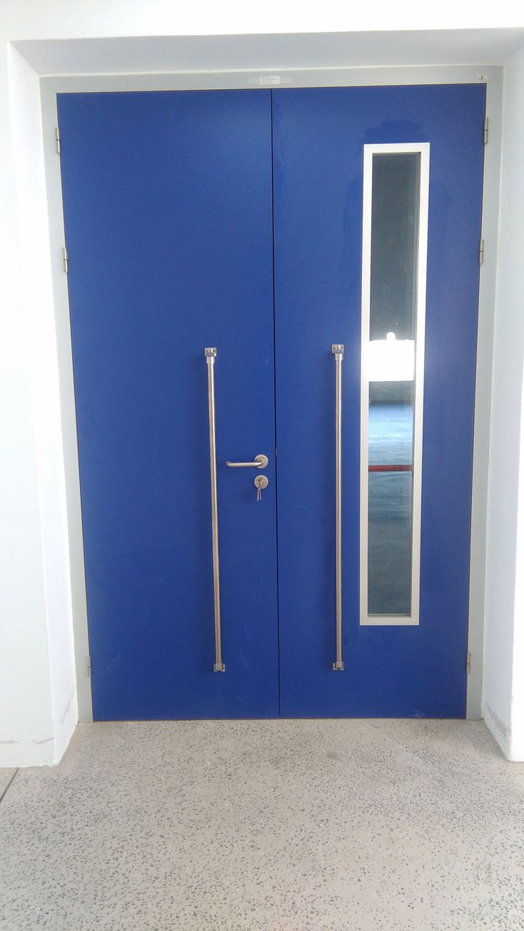 Una puerta azul con manijas de acero inoxidable y una ventana.