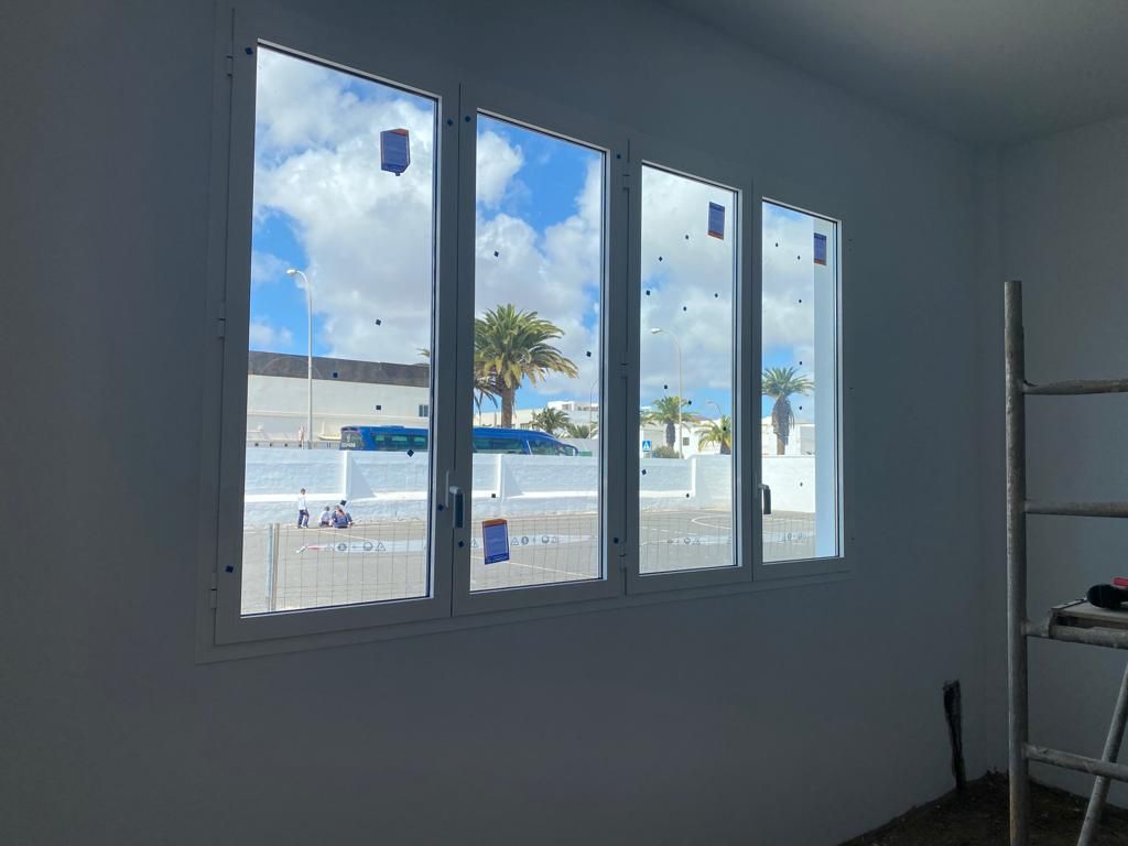 Una habitación con muchas ventanas y una escalera.