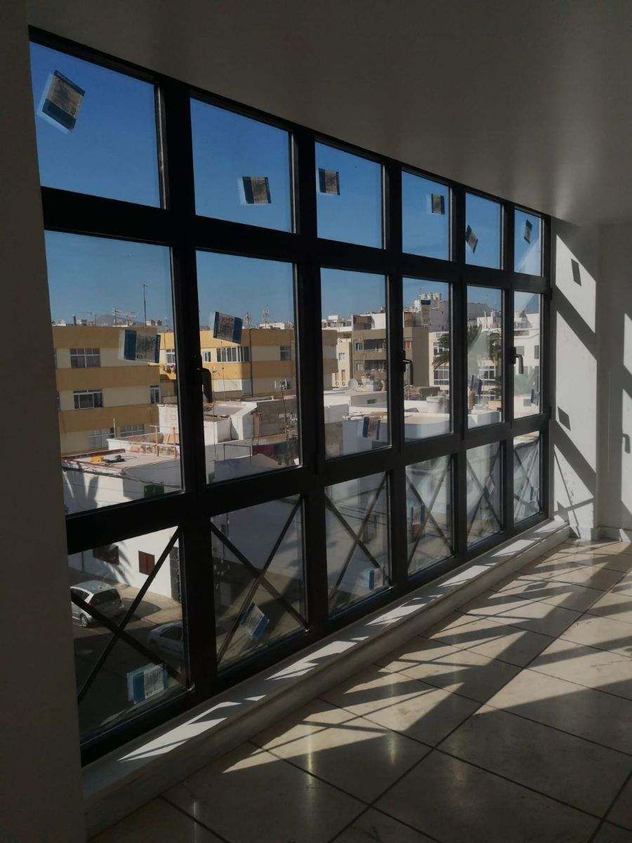 Una habitación con muchas ventanas y vistas a una ciudad.