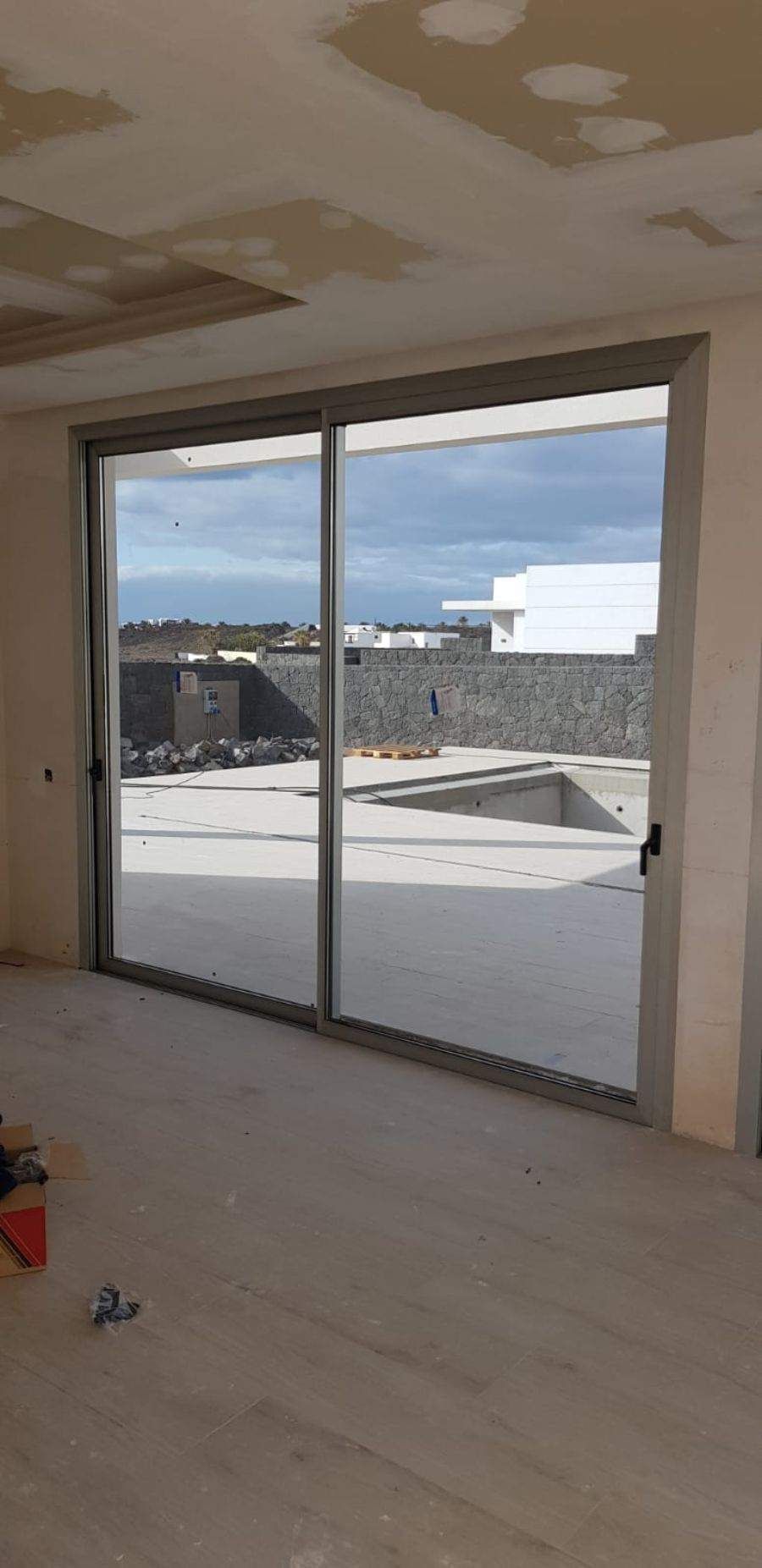 Una gran puerta corrediza de vidrio en una habitación con vista a una piscina.