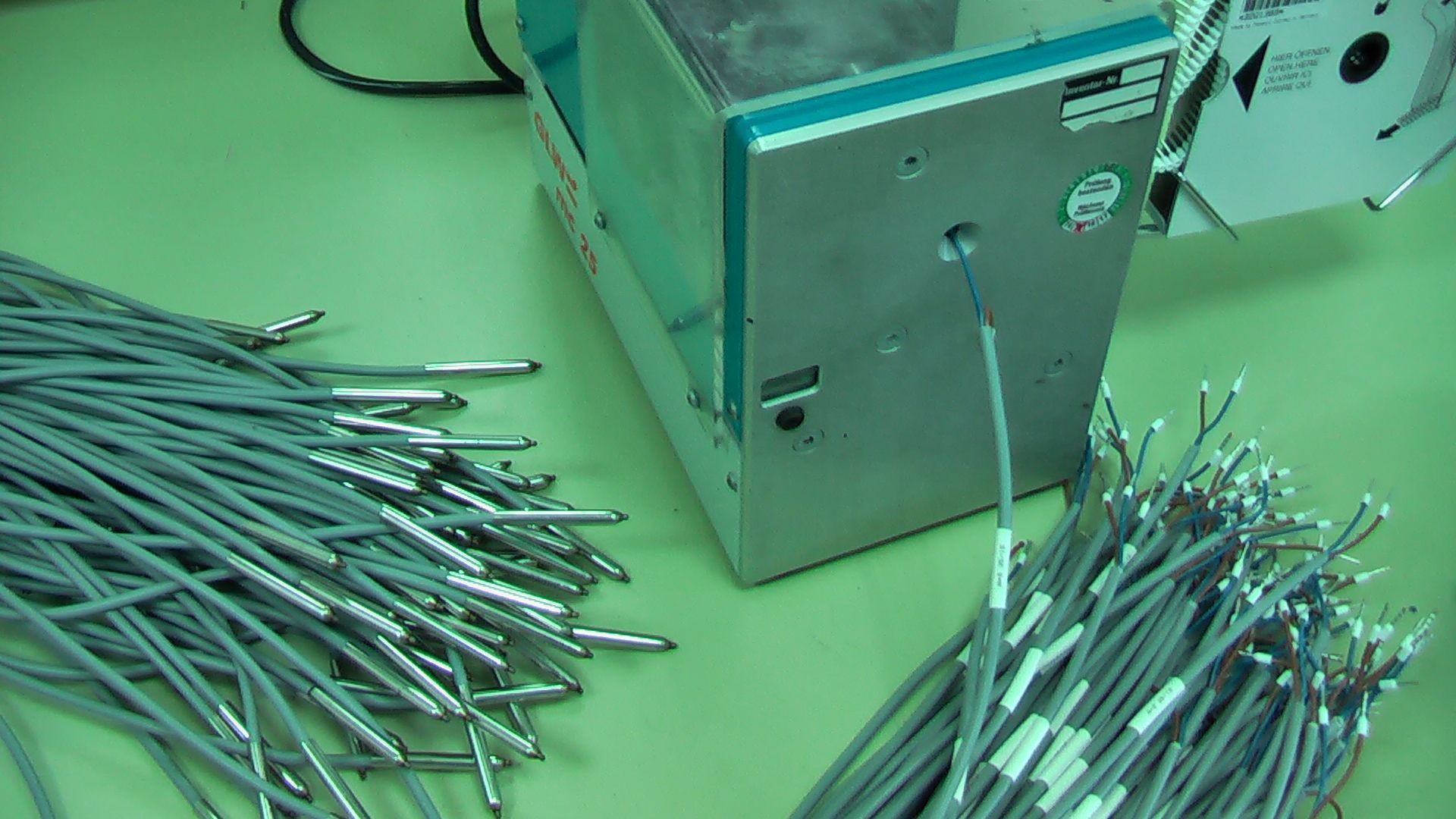 A bunch of wires are sitting on a table next to a machine
