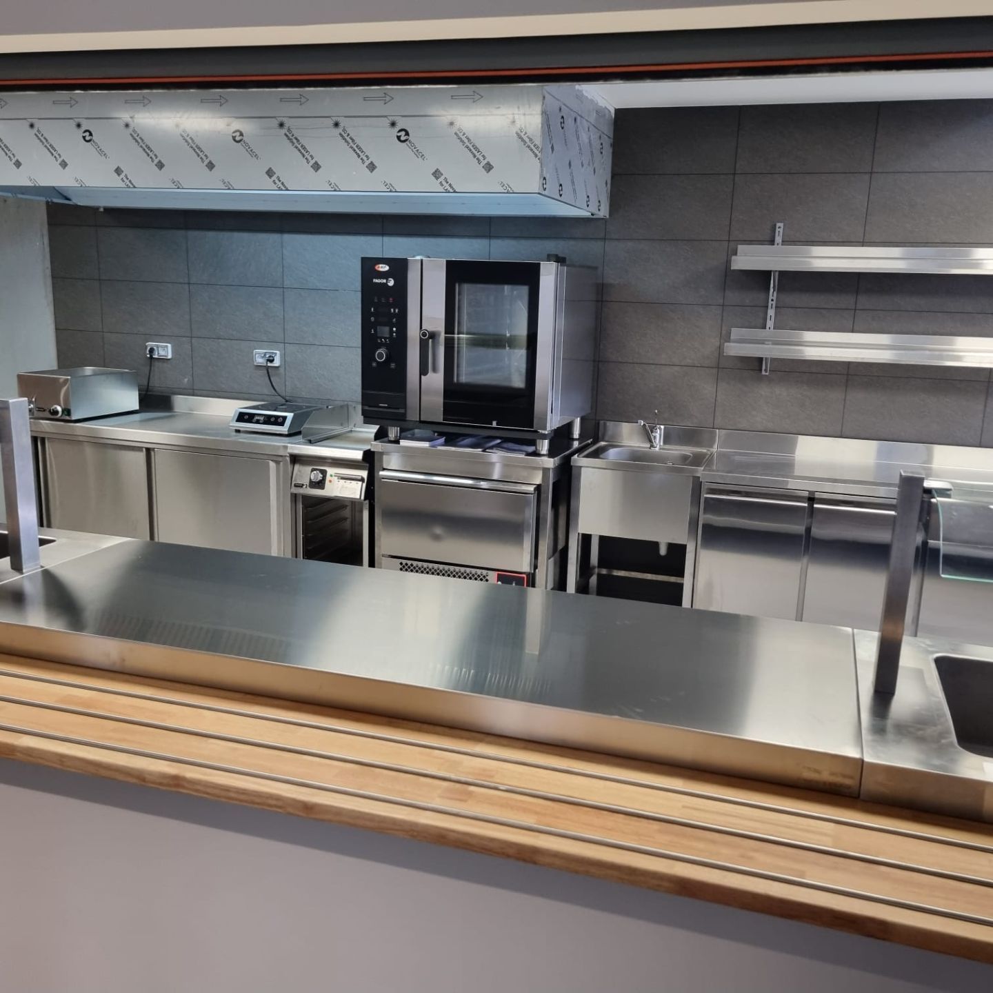 Cuisine commerciale en acier inoxydable avec équipements et étagères.