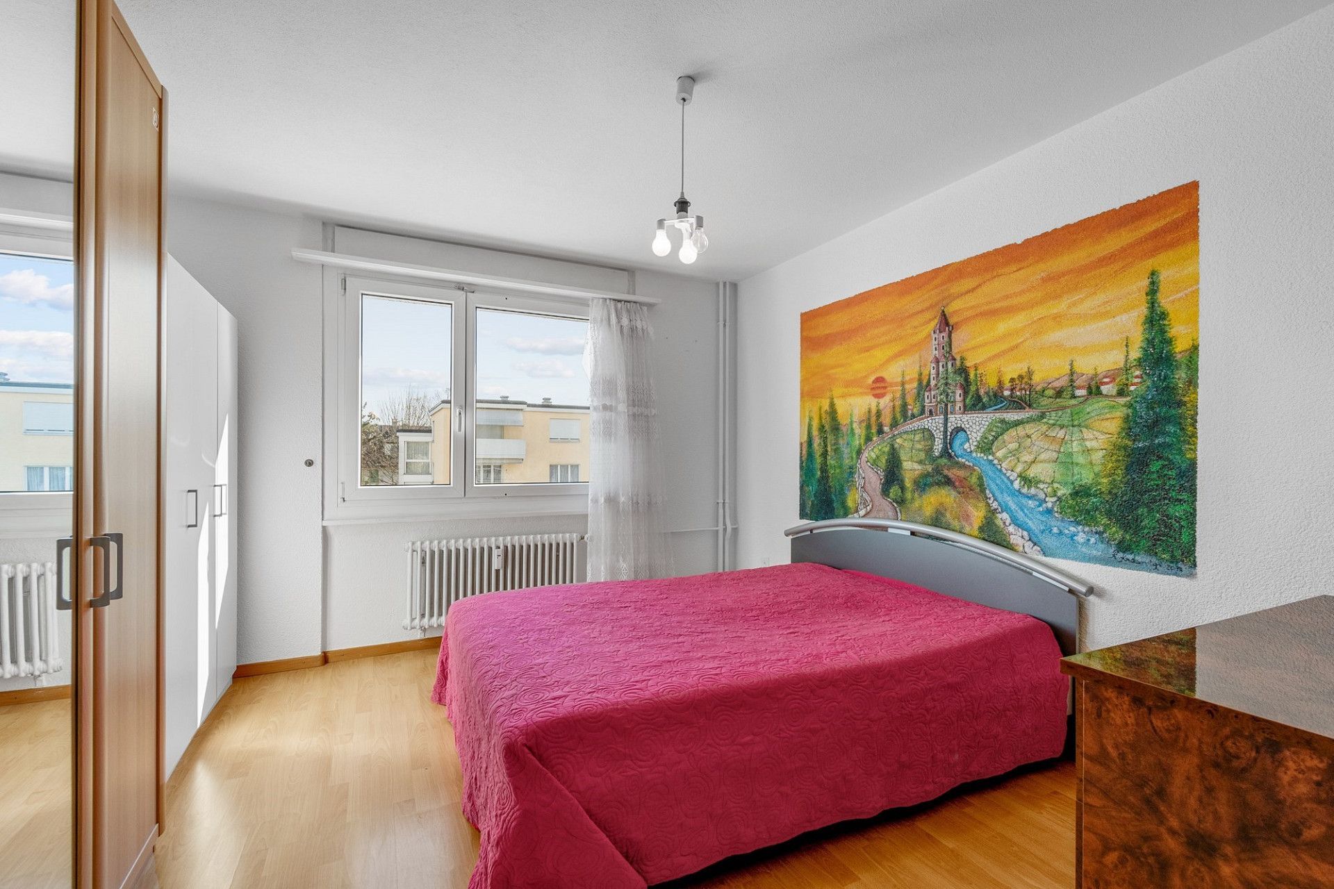 Ein Schlafzimmer mit einem Bett und einem Gemälde an der Wand