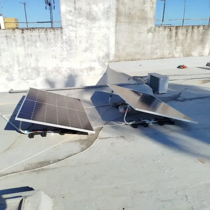Conjunto de paneles solares instalados en el tejado, junto a una pequeña antena parabólica y una caja de equipos.