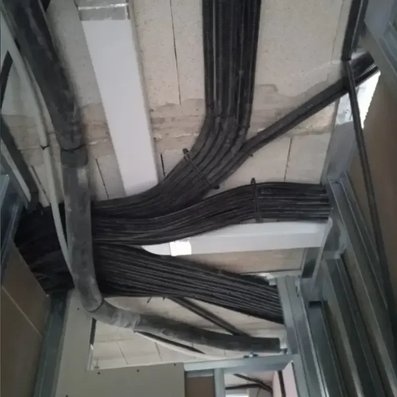 Cables negros agrupados y enrutados a través de un espacio de servicio en el techo