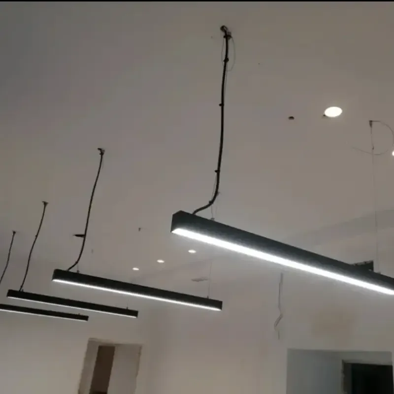 Tres lámparas colgantes negras cuelgan de un techo blanco en una habitación moderna.
