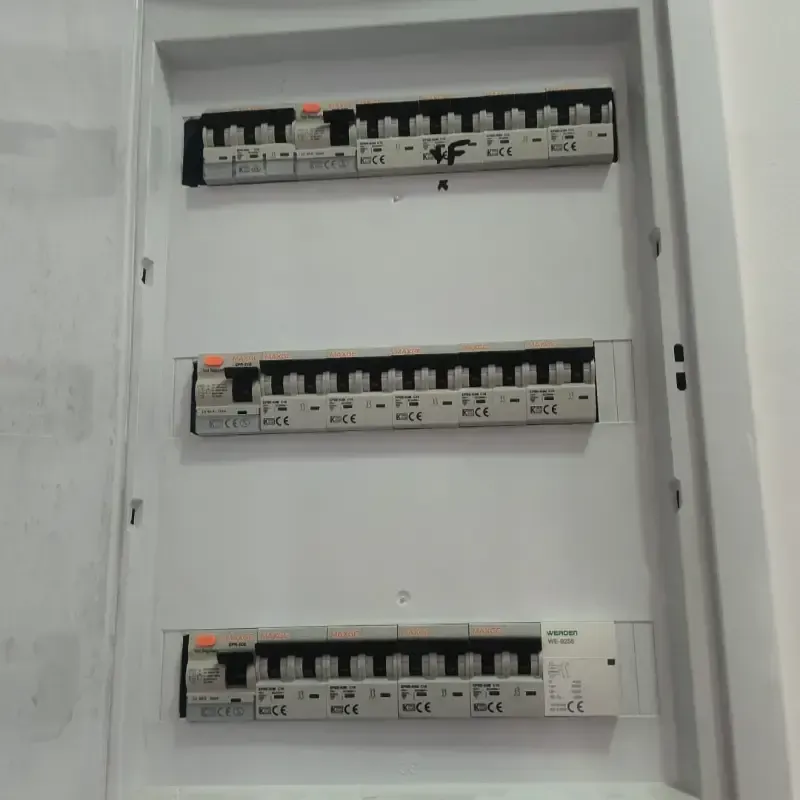 Panel de interruptores eléctricos abierto con tres filas de interruptores automáticos y etiquetas blancas.