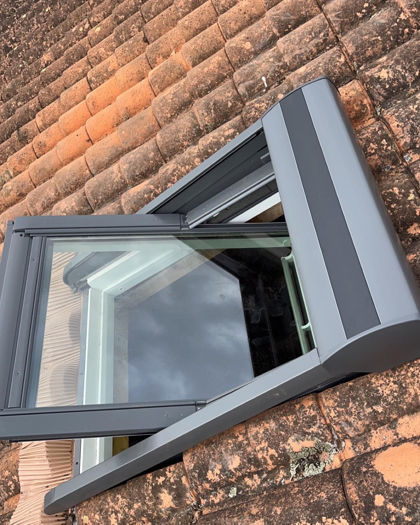 Fenêtre de toit entrouverte pour une toiture en tuiles