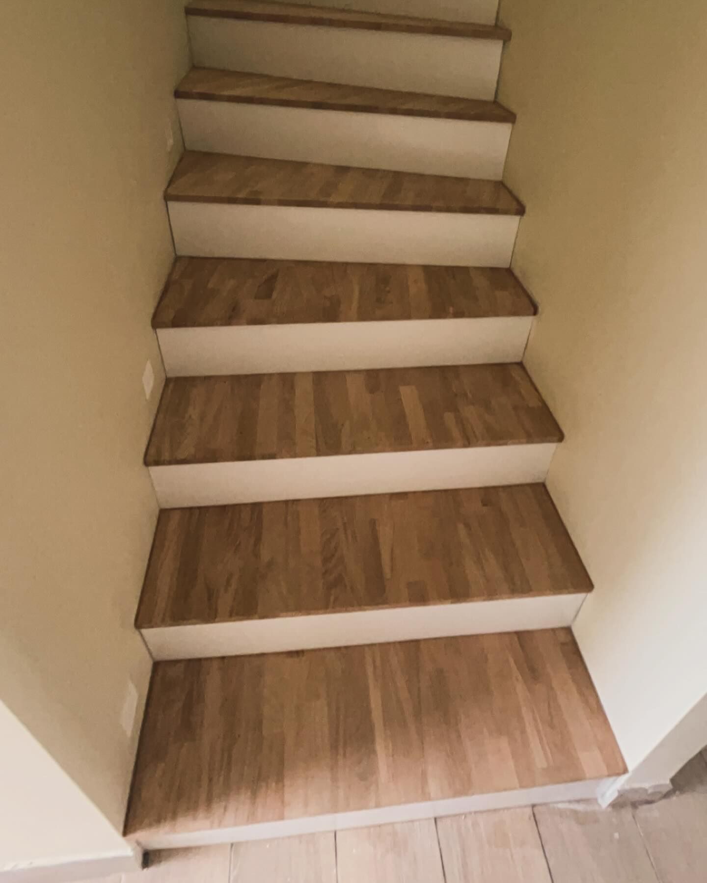 Escalier composé de marches en bois et des spots lumineux sur le côté