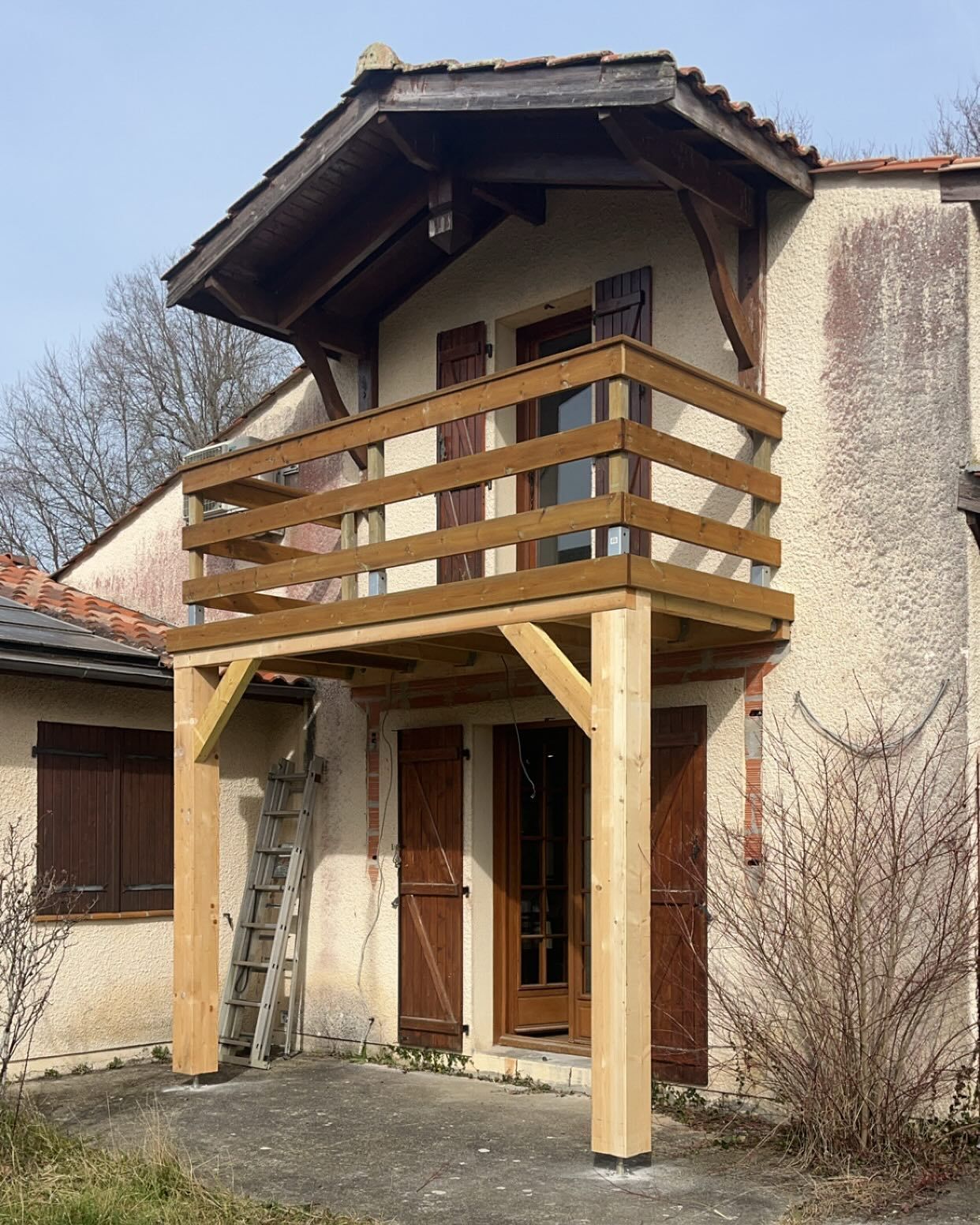 Installation d'un balcon en bois avec des poutres de soutien
