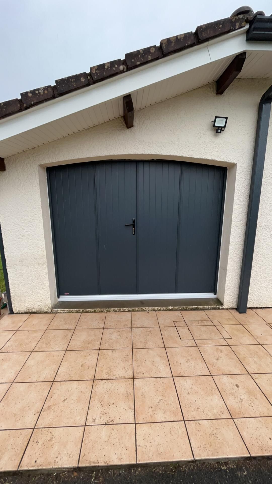 Installation d'une porte de garage sectionnelle noire sur mesure