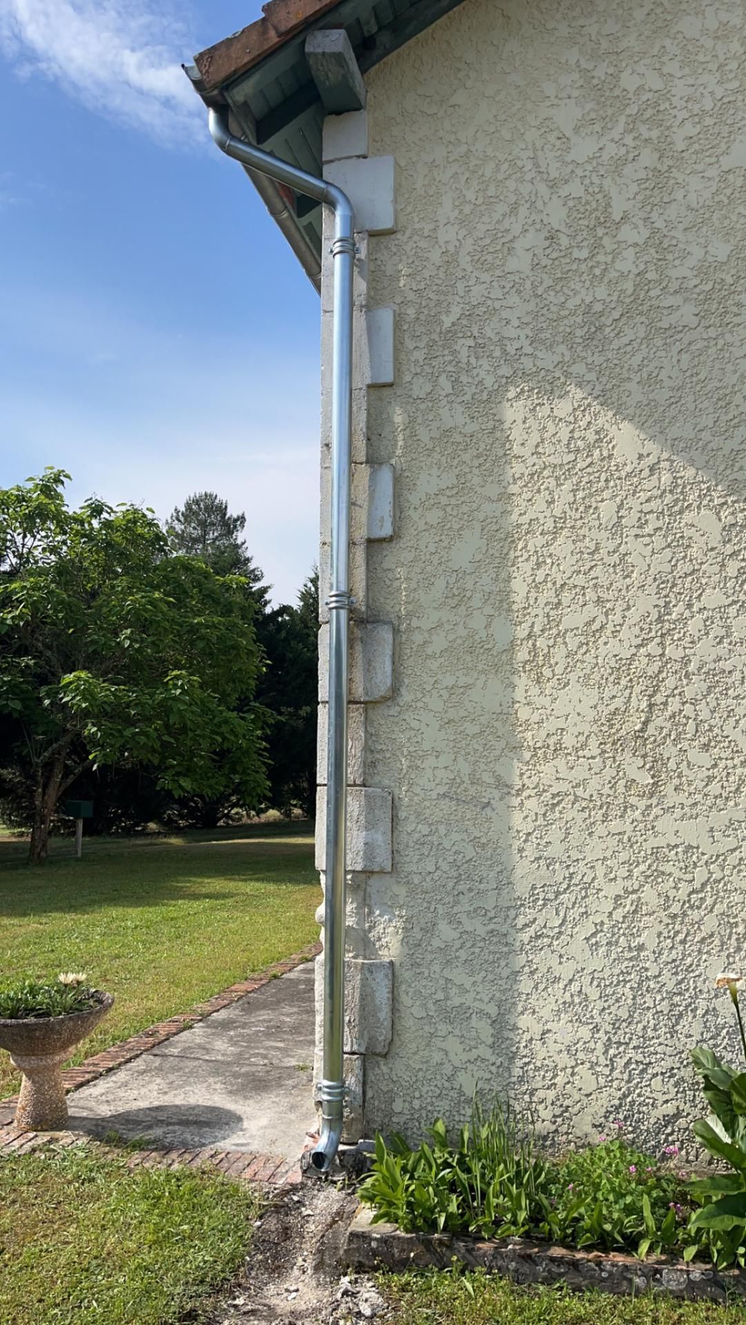 Installation terminée d'une descente  de pluie le long d'une façade