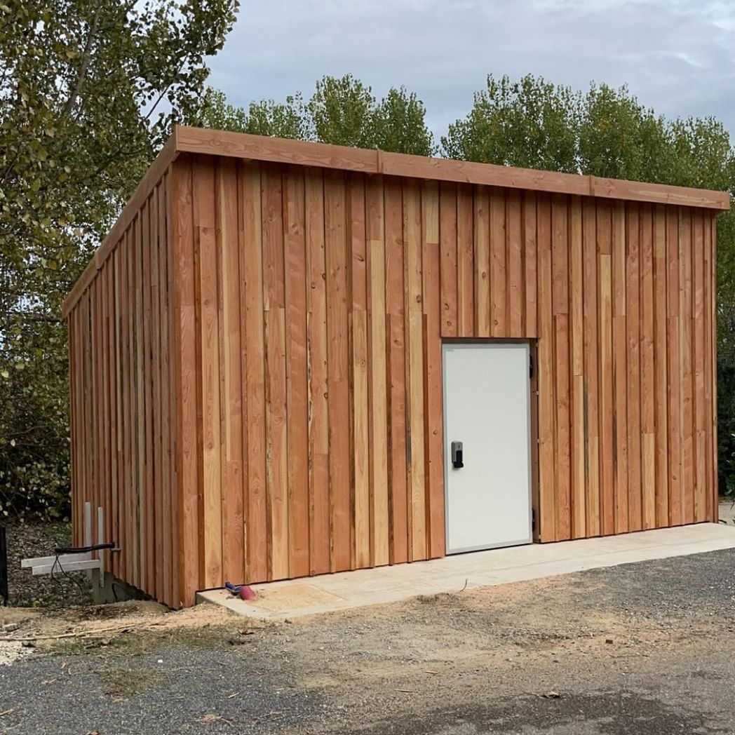 Abri de jardin en bois terminé, avec une porte blanche