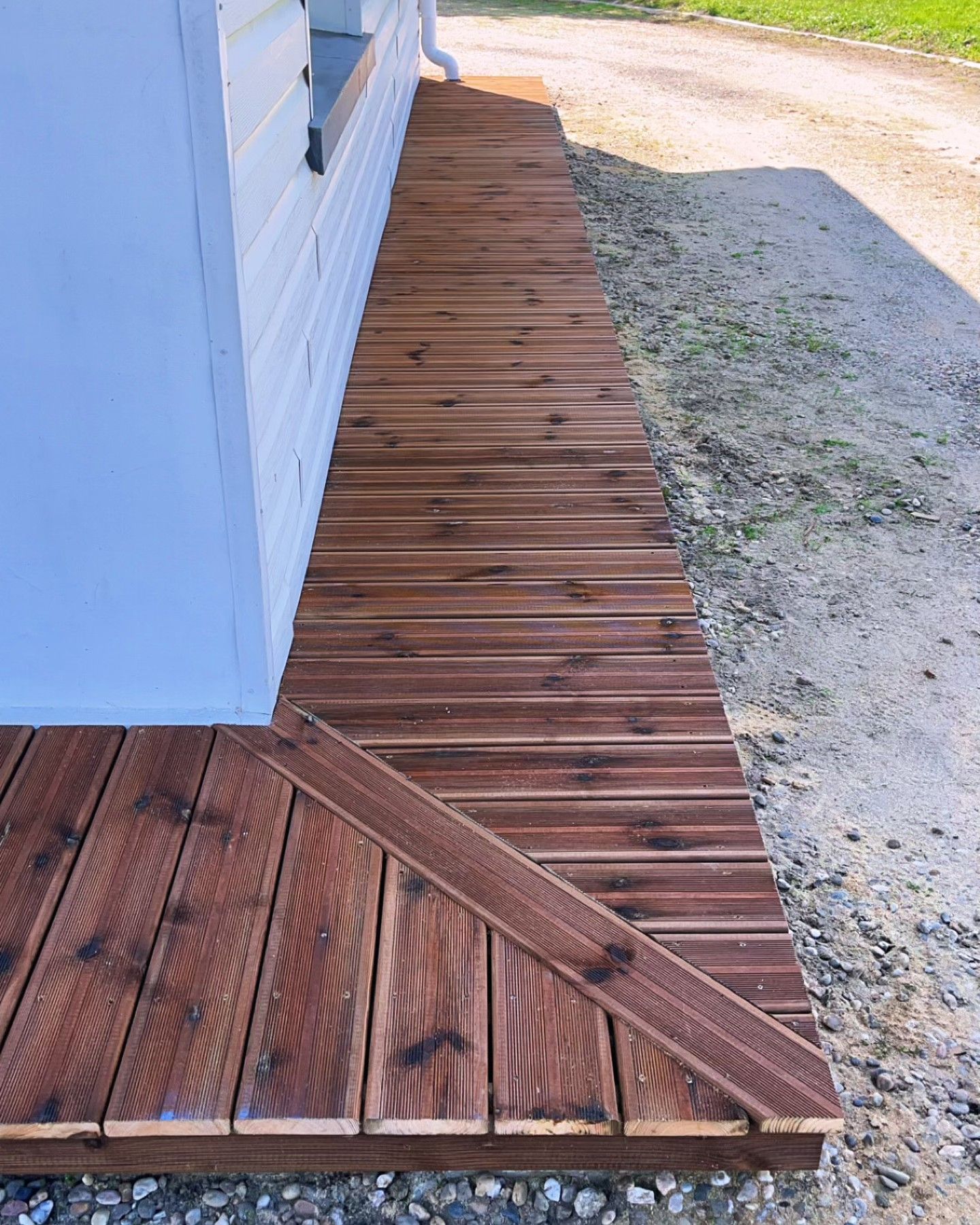 Terrasse en bois terminée pour entourer les fondations d'une maison