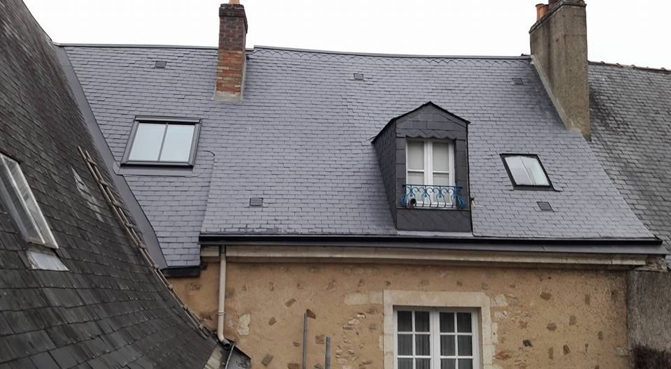 Vue d'un toit de maison avec des Velux et une fenêtre