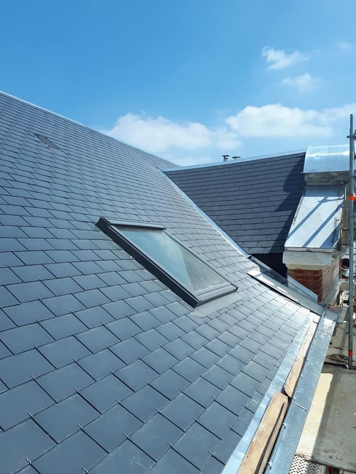 Un toit avec un Velux et des tuiles en aluminium