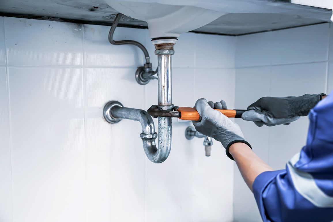 Tuyau de lavabo serré avec une clé