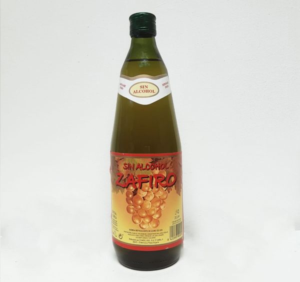 Una botella de zafiro reposa sobre una superficie blanca.