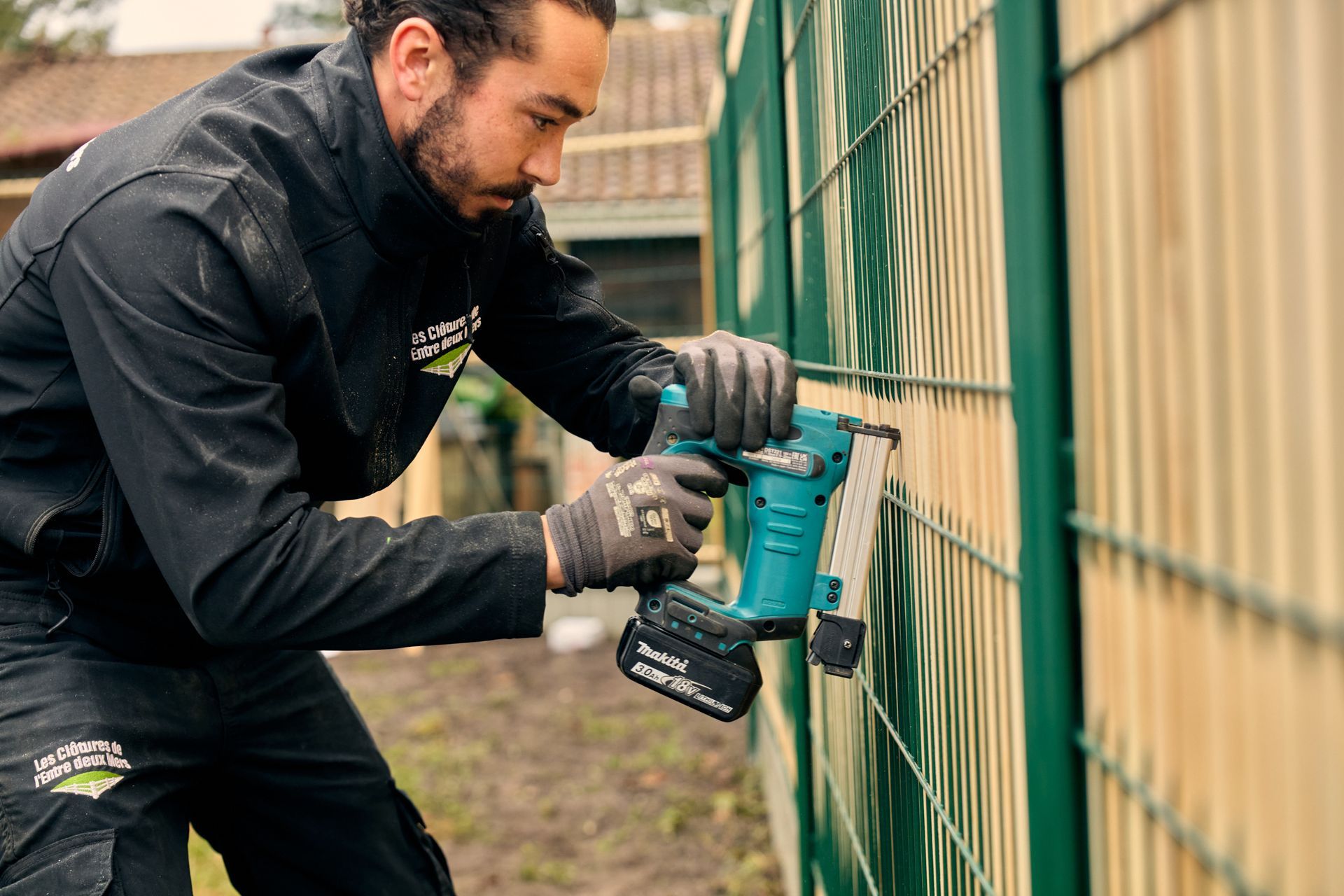 Artisan posant une clôture en bois et aluminium
