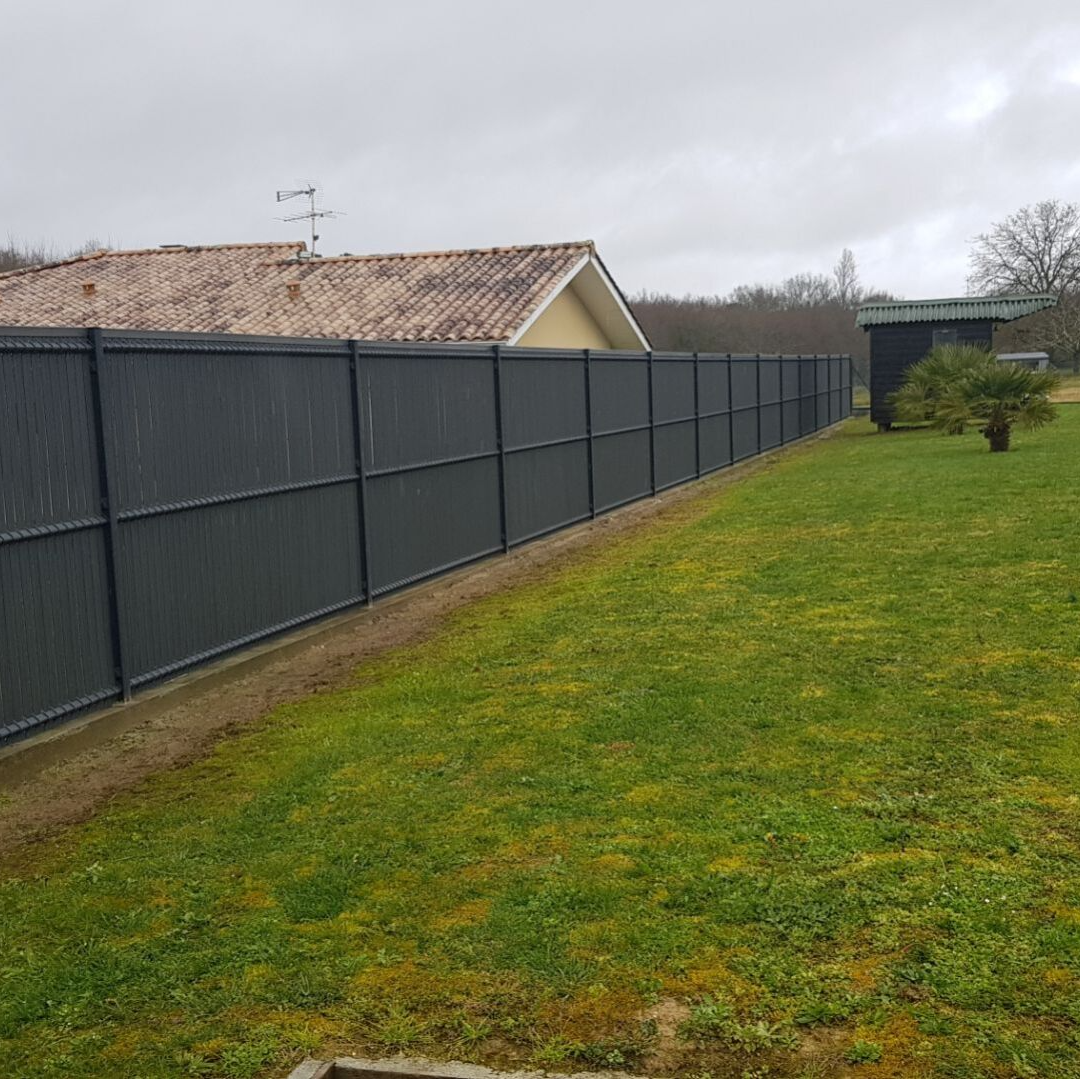 Clôture rigide moderne le long d'un grand jardin