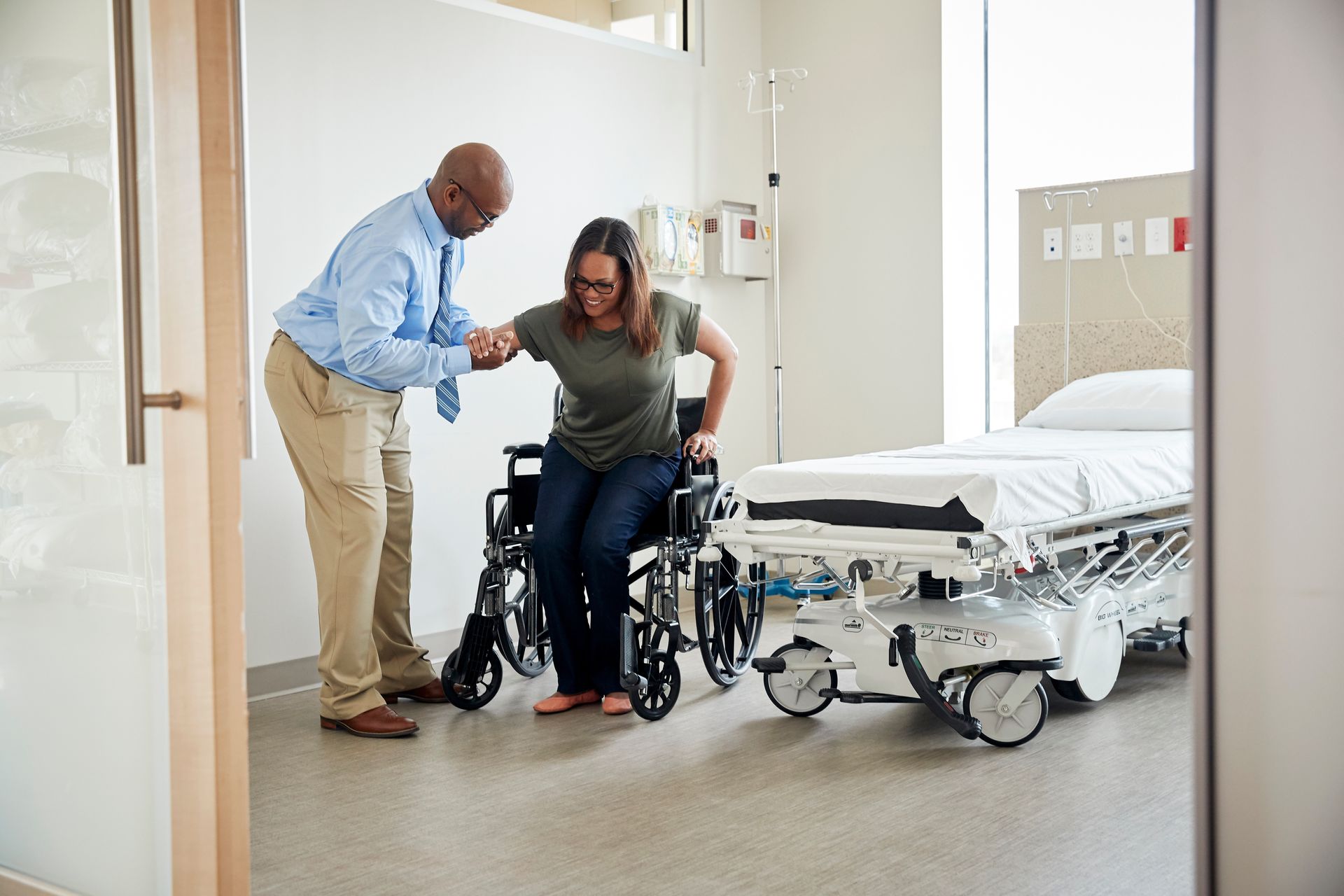 Une personne aide une PMR dans un fauteuil roulant