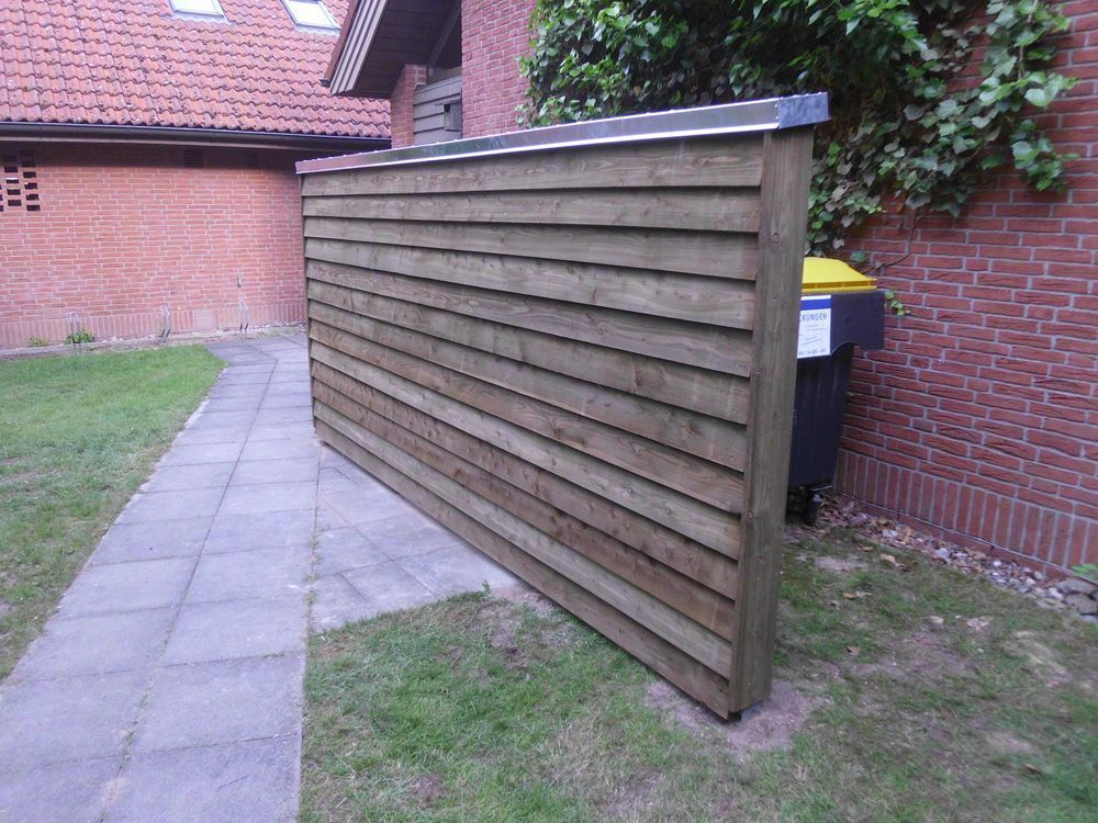 Ein Backsteingebäude mit einem Holzzaun davor