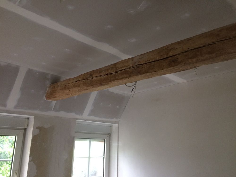 Ein Raum mit einem Holzbalken, der von der Decke hängt.