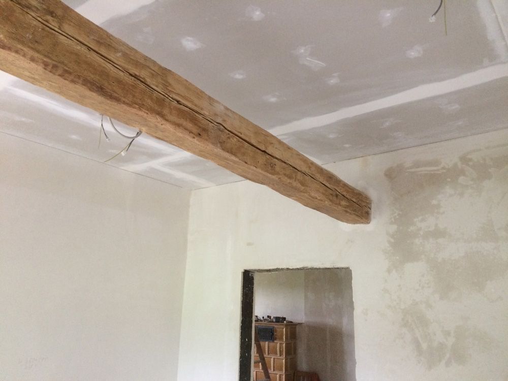 Ein Raum mit einem Holzbalken, der von der Decke hängt.