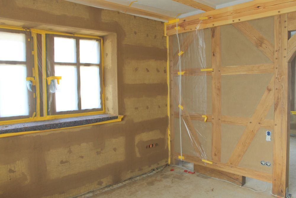 Ein Raum mit Holzwänden und einem Fenster in einem im Bau befindlichen Haus.